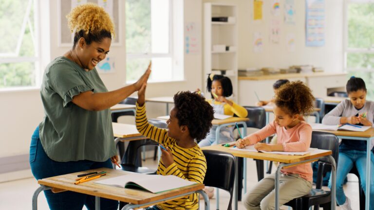Teacher high-fiving their students hand