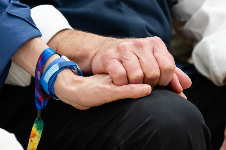 holding hands with a steelmike bracelet on a leg