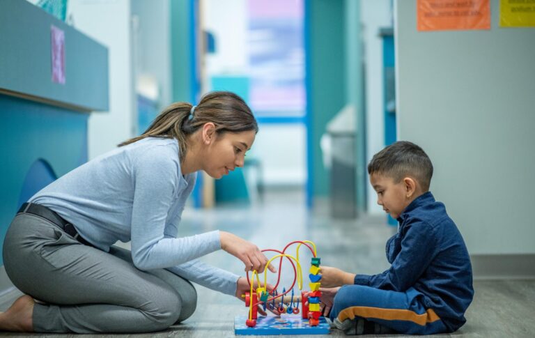 teacher and boy playing with toy